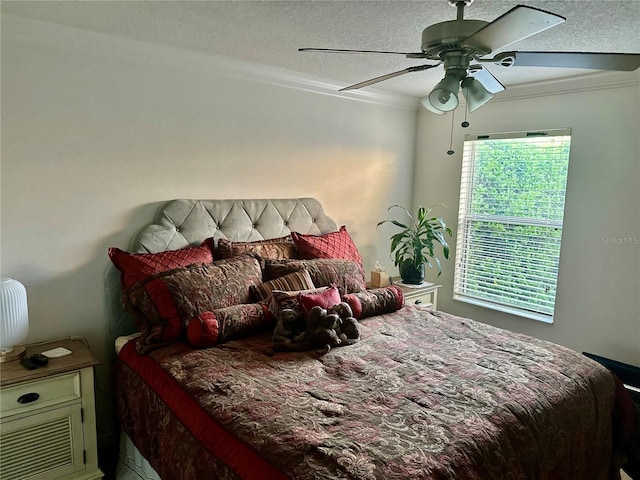 bedroom featuring ceiling fan, ornamental molding, and a textured ceiling