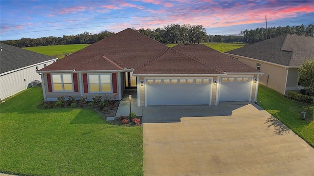 ranch-style house featuring concrete driveway, a front lawn, and an attached garage