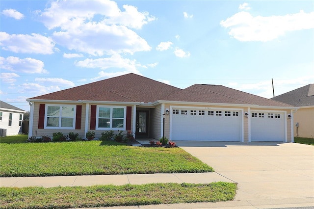 ranch-style home featuring driveway, a garage, and a front yard