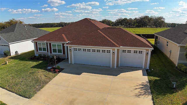 view of front of house with concrete driveway, a front lawn, and an attached garage