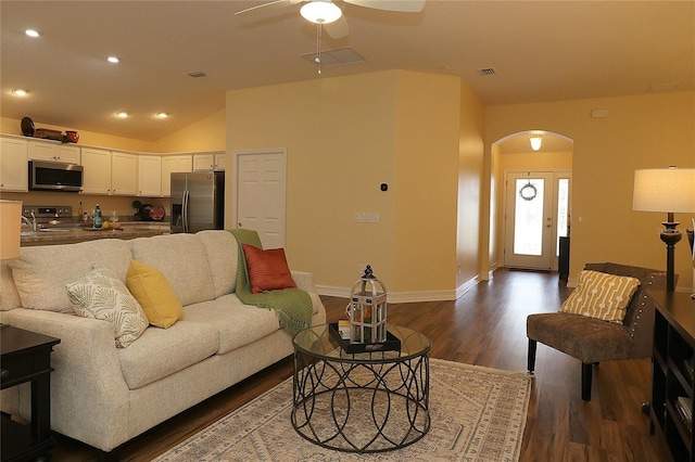 living room with arched walkways, dark wood finished floors, recessed lighting, visible vents, and vaulted ceiling