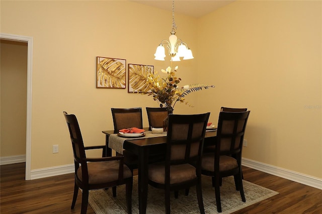 dining room featuring a chandelier, dark wood finished floors, and baseboards