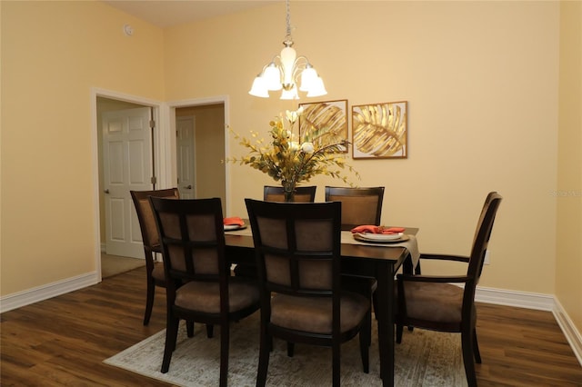 dining space with a notable chandelier, dark wood-type flooring, and baseboards