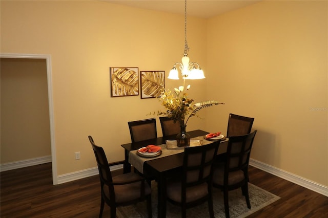 dining room featuring dark wood-style floors, baseboards, and a notable chandelier