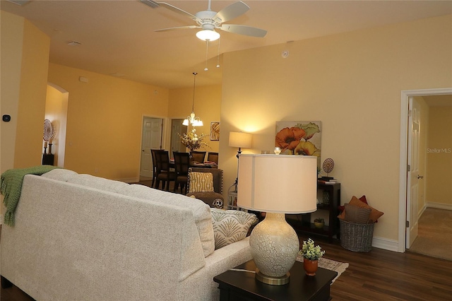 living area with ceiling fan with notable chandelier, arched walkways, baseboards, and wood finished floors