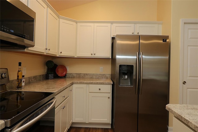 kitchen featuring white cabinetry, vaulted ceiling, appliances with stainless steel finishes, and light countertops