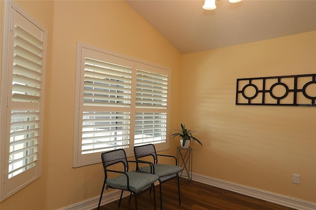 sitting room with baseboards, vaulted ceiling, and wood finished floors