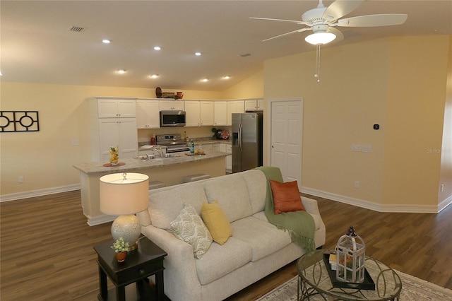 living area with dark wood finished floors, visible vents, and baseboards