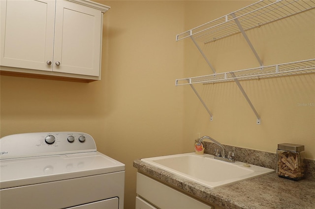 clothes washing area featuring washer / clothes dryer, cabinet space, and a sink