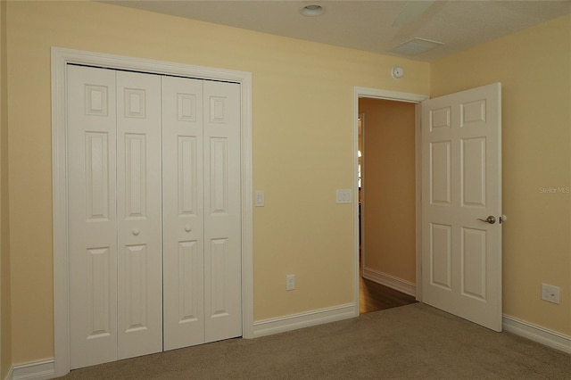 unfurnished bedroom featuring carpet floors, baseboards, visible vents, and a closet