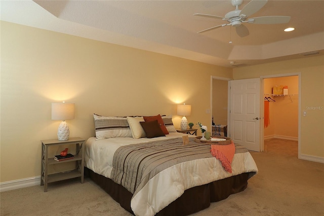 bedroom with light carpet, a spacious closet, visible vents, and baseboards