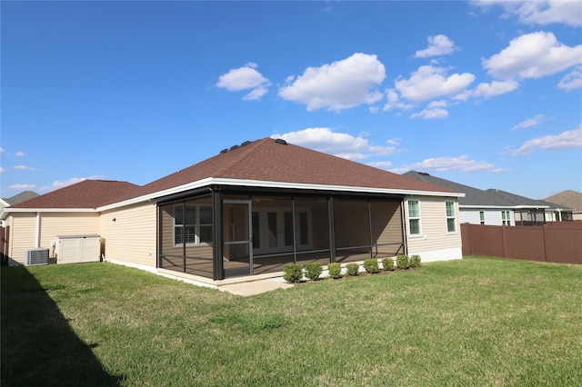 back of house with a yard, a sunroom, and fence