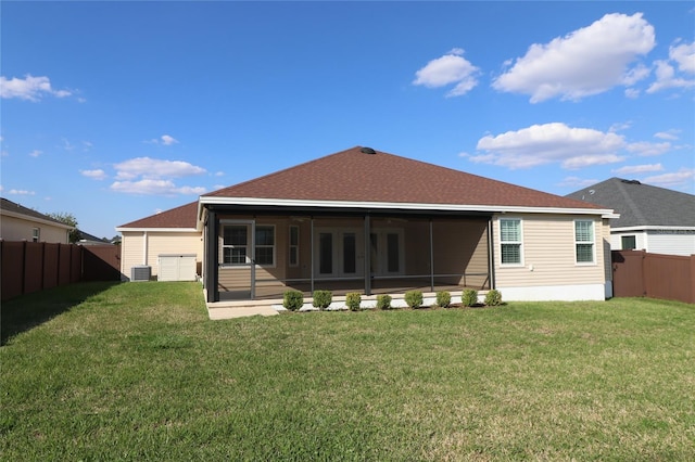 back of house with a sunroom, a fenced backyard, central AC unit, and a yard