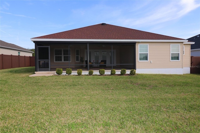 back of house featuring a sunroom, fence, and a yard