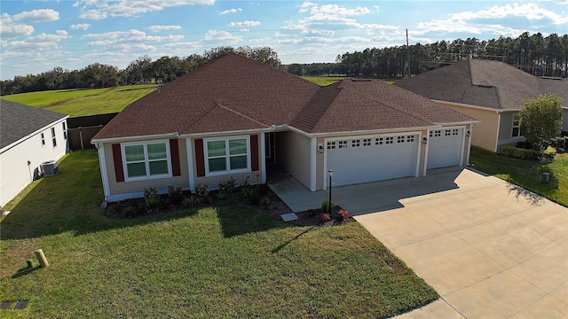 view of front of house featuring an attached garage, driveway, and a front lawn