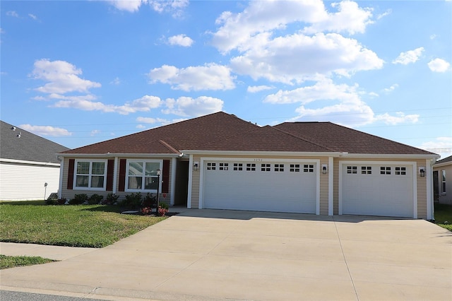 ranch-style home with driveway, an attached garage, and a front yard