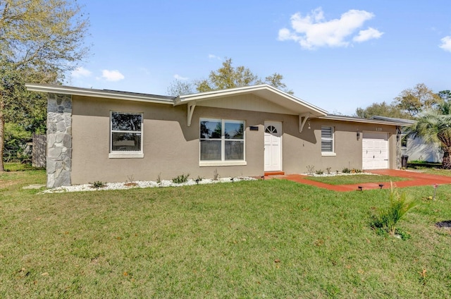 ranch-style house featuring stucco siding, an attached garage, and a front yard