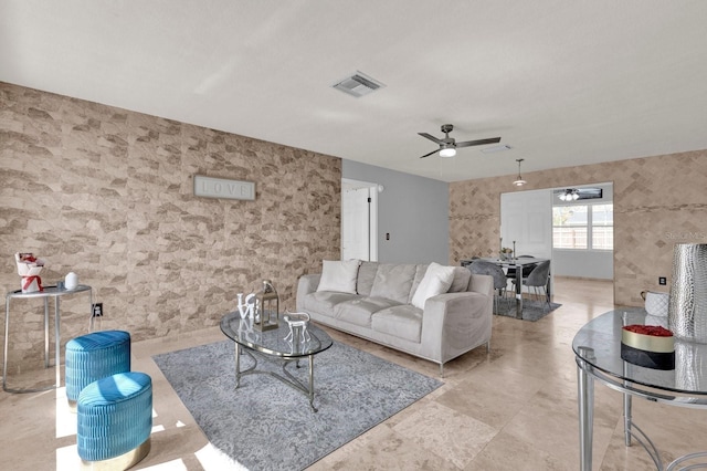 living room with visible vents, wallpapered walls, and a ceiling fan