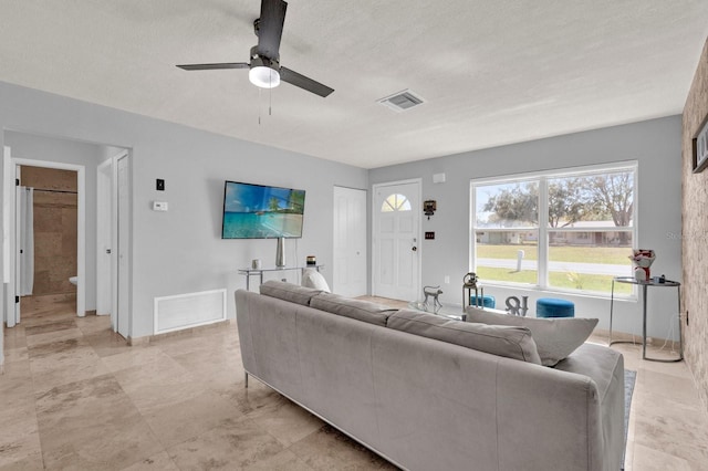 living room featuring visible vents and ceiling fan