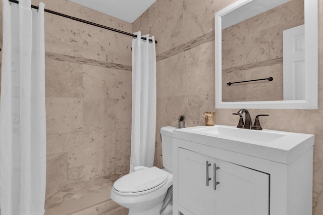 full bathroom with toilet, a stall shower, vanity, and tile walls