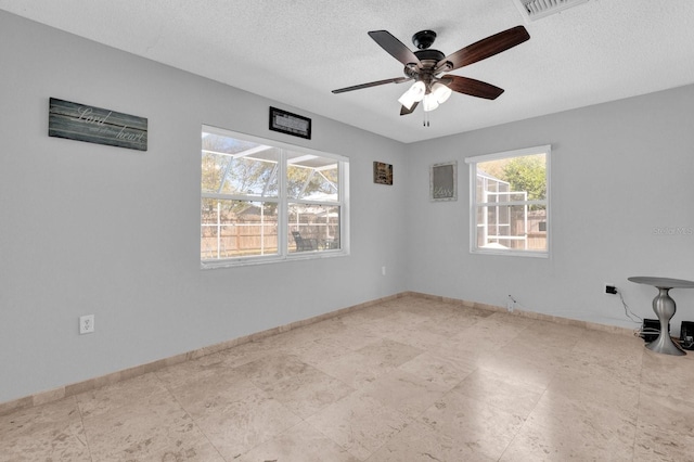 empty room featuring visible vents, baseboards, a textured ceiling, and a ceiling fan