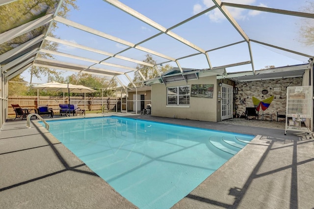 view of pool with a fenced in pool, glass enclosure, a patio, and fence