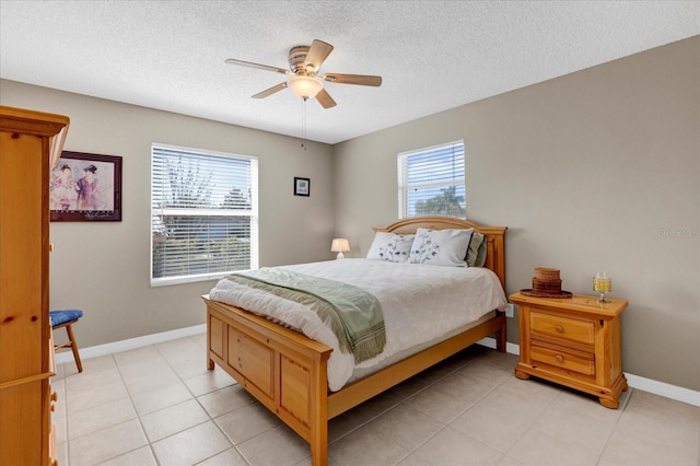 bedroom with ceiling fan, multiple windows, baseboards, and a textured ceiling