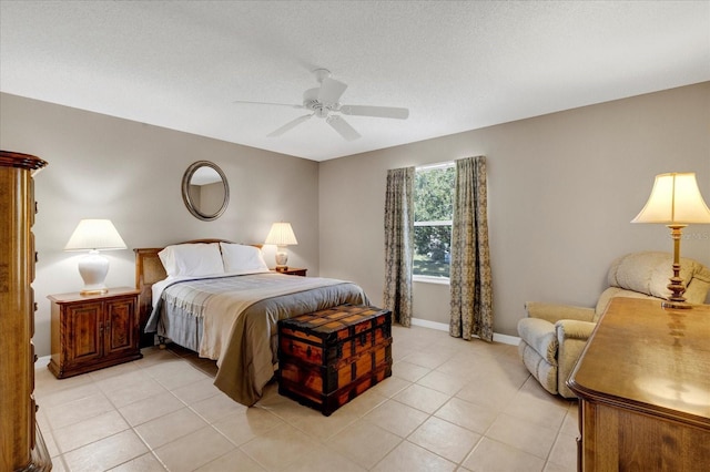 bedroom with light tile patterned floors, a ceiling fan, baseboards, and a textured ceiling