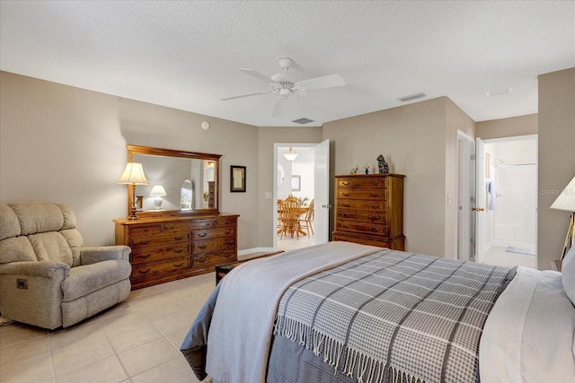 bedroom featuring light tile patterned floors, a textured ceiling, visible vents, and a ceiling fan