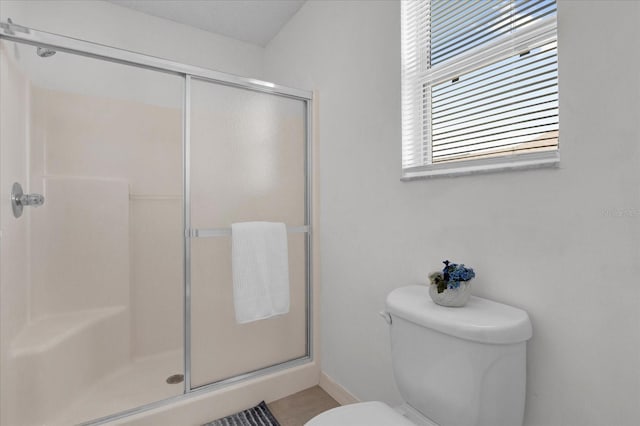 bathroom with toilet and a stall shower