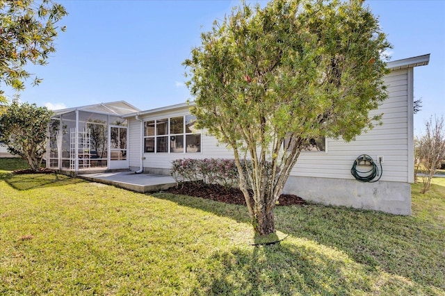 rear view of property featuring glass enclosure, a patio area, and a yard