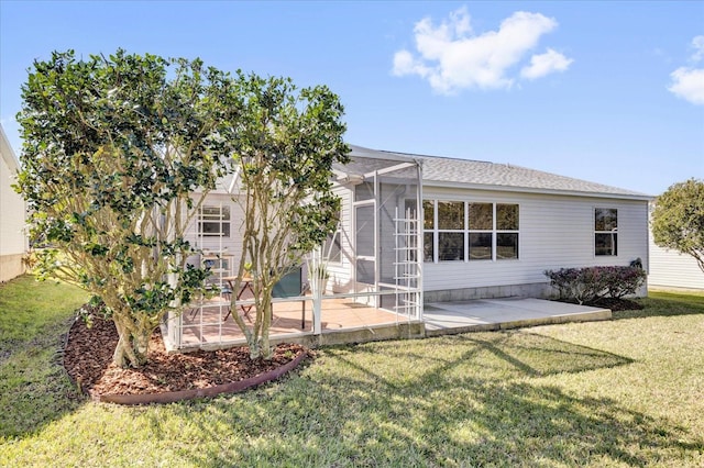 back of property with a lanai, a lawn, and a patio