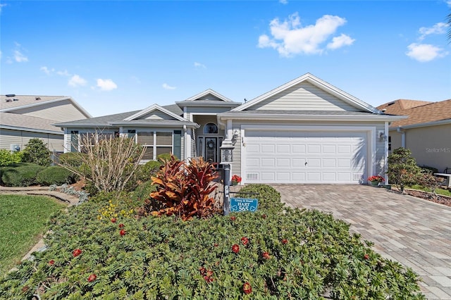 single story home featuring decorative driveway and an attached garage