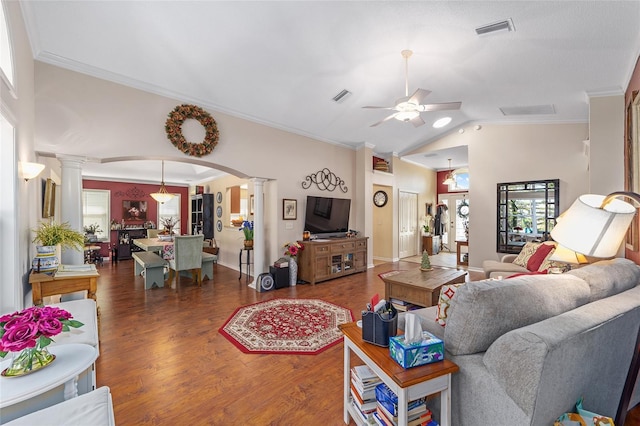 living area with visible vents, wood finished floors, arched walkways, and decorative columns