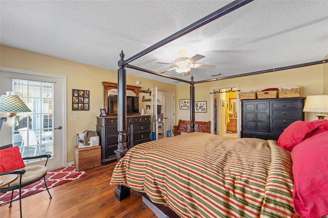 bedroom featuring a textured ceiling, wood finished floors, a ceiling fan, and ensuite bathroom