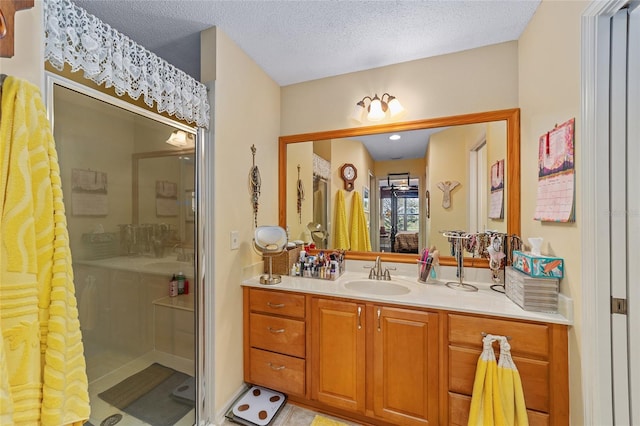 bathroom featuring a shower stall, vanity, and a textured ceiling