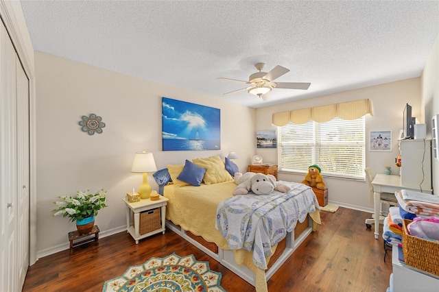 bedroom featuring ceiling fan, a textured ceiling, wood finished floors, baseboards, and a closet