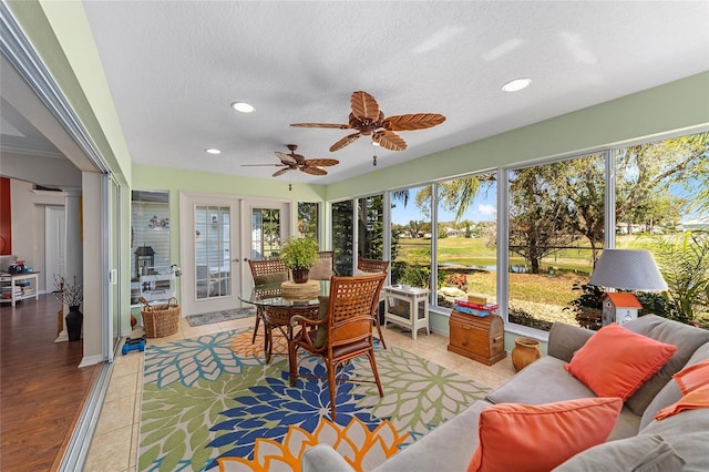 sunroom / solarium featuring french doors, a ceiling fan, and ornate columns