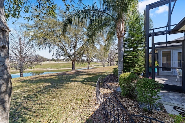 view of yard featuring glass enclosure and a water view