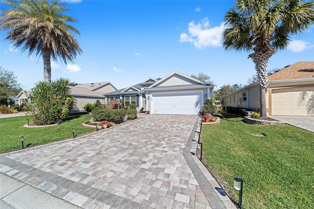 ranch-style home with decorative driveway, an attached garage, and a front lawn