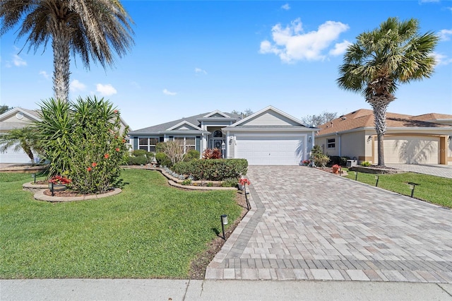 ranch-style house featuring a garage, a front lawn, and decorative driveway