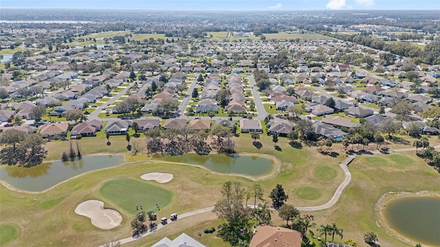 drone / aerial view featuring a residential view, view of golf course, and a water view