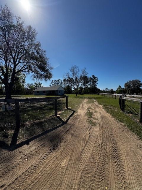 view of community with a rural view and fence