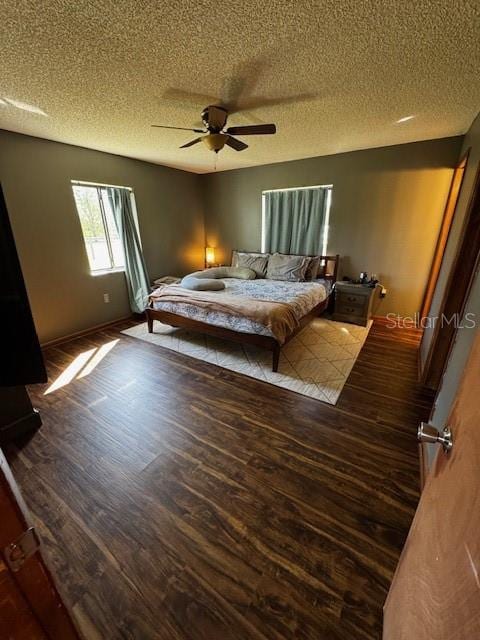 bedroom with a textured ceiling, wood finished floors, and a ceiling fan