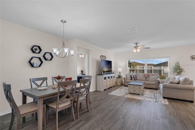 dining area with ceiling fan with notable chandelier, visible vents, baseboards, and wood finished floors