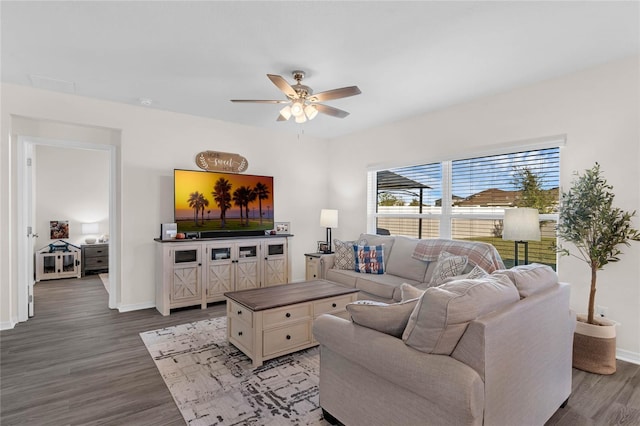 living area featuring wood finished floors, a ceiling fan, and baseboards