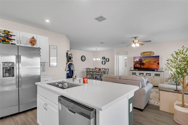 kitchen with visible vents, white cabinets, appliances with stainless steel finishes, light countertops, and a sink