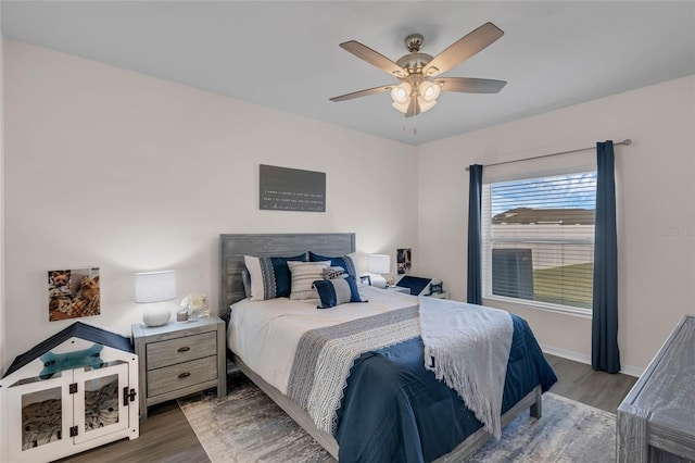 bedroom featuring ceiling fan, baseboards, and wood finished floors