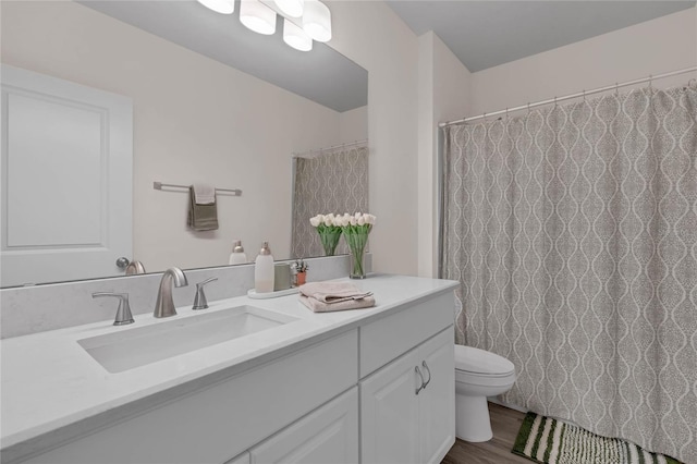 bathroom featuring vanity, toilet, and wood finished floors