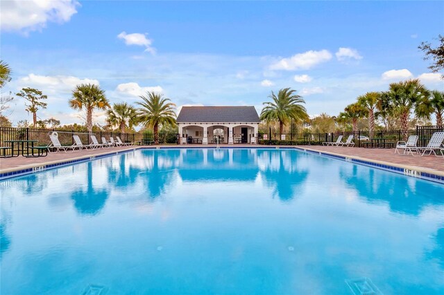 pool with a patio area and fence